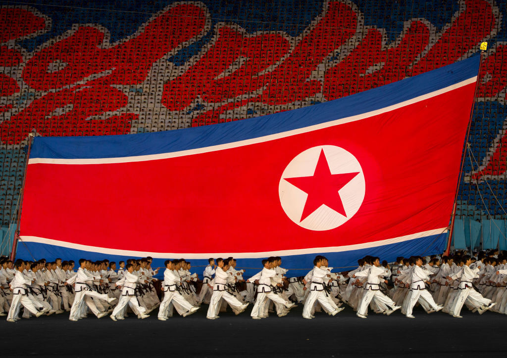 North Korean taekwondo team in front of a giant flag during the Arirang mass games in may day stadium, Pyongan Province, Pyongyang, North Korea