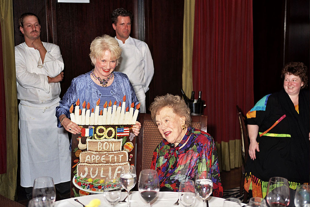 Chef Julia Child is presented with a card designed by gallery owner, Nancy Thomas, during a charity pre-birthday dinner