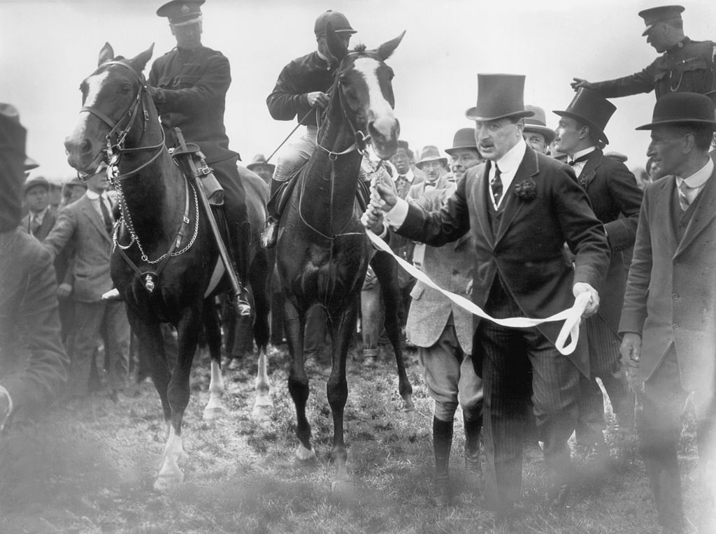 black and white photo showing a horse being led to a race