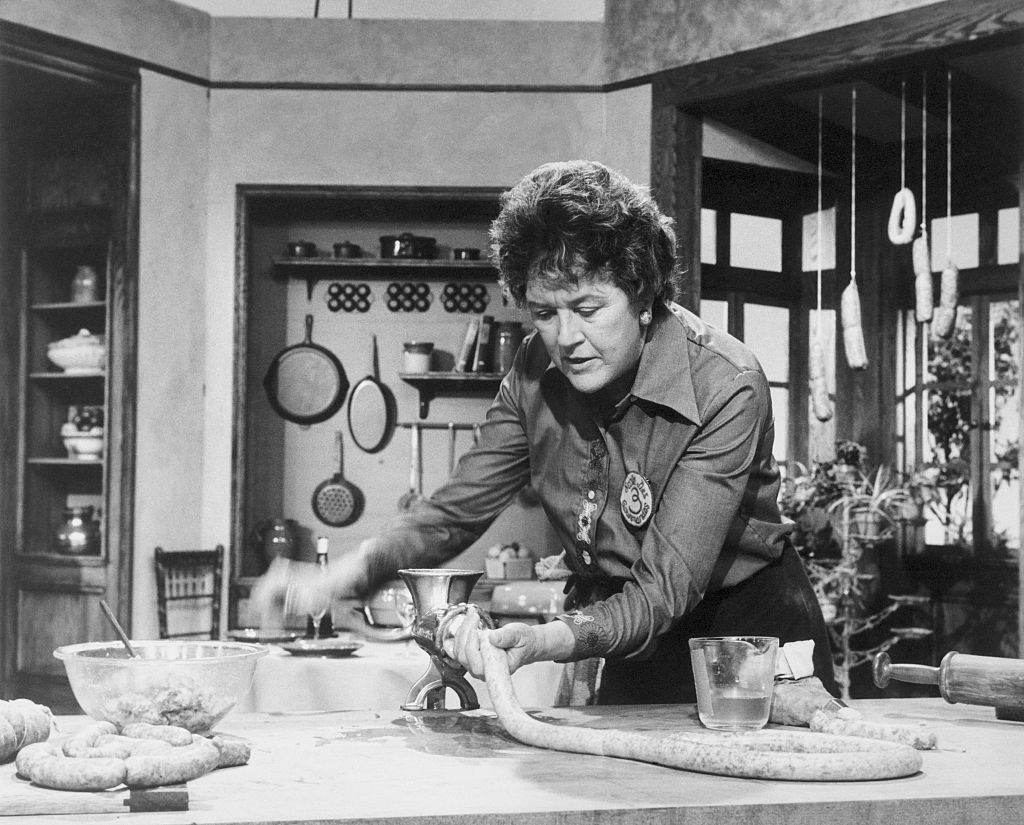 Julia child demonstrates the stuffing of sausages.