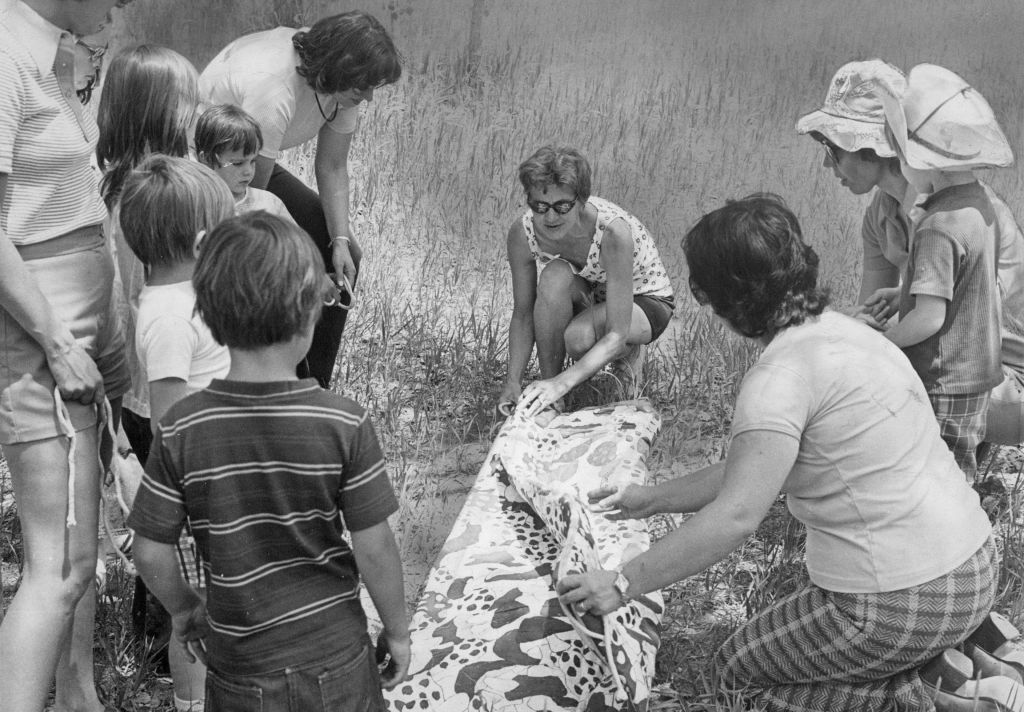 campers learn how to fold a bedroll