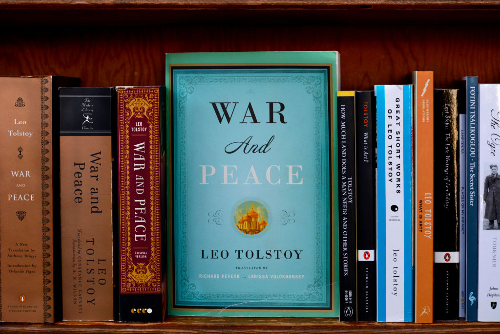 various copies of war and piece lined up on a bookshelf