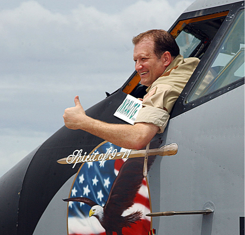 Comedian Drew Carey gestures out the window of a KC-135 Stratotanker December 25, 2002 as he visits Camp Justice in Afghanistan.