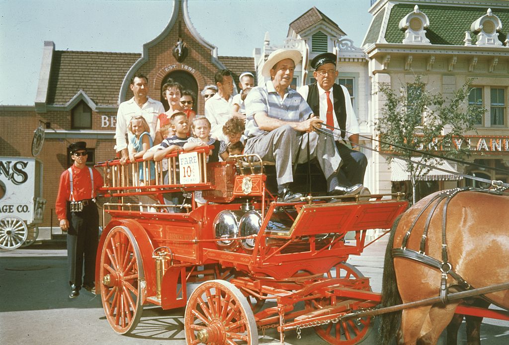 walt disney and other disneyland guest on top of a horsedrawn fire wagon