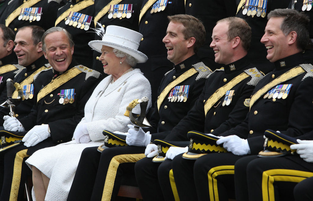 Queen Elizabeth II and Brigadier Mel Jamieson (second left) laugh as an officers group picture is taken