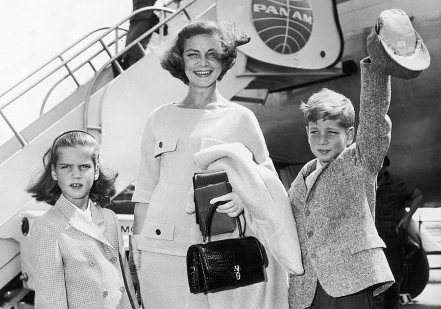 bacall and children in front of a plane