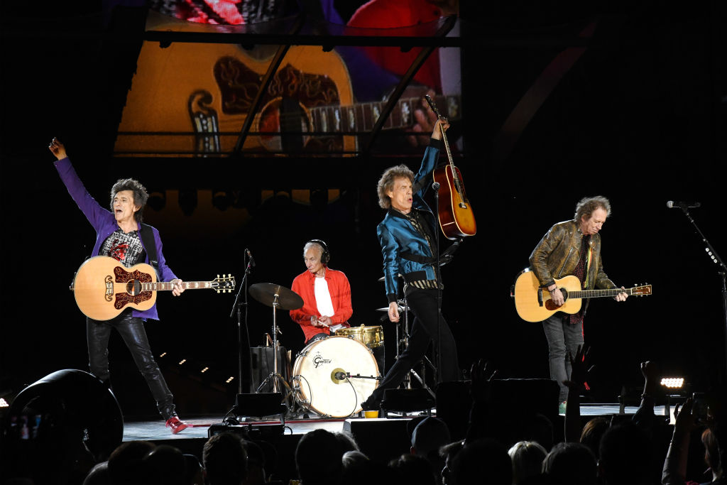 the rolling stones: ronnie wood, charlie watts, mick jagger, and keith richards performing on stage