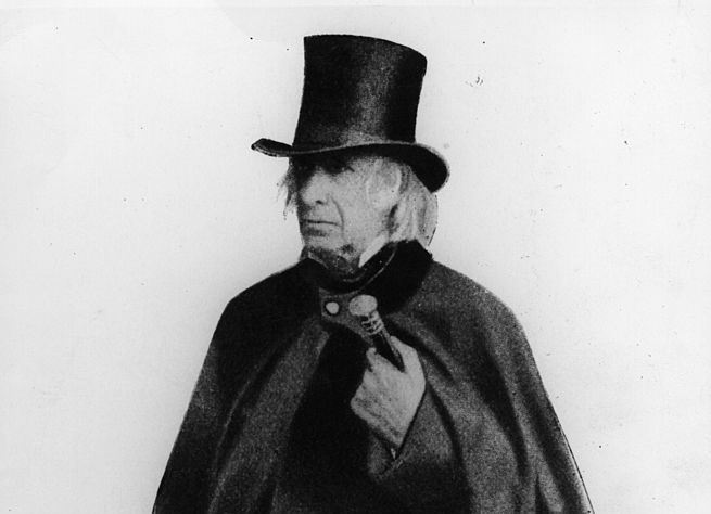 Amos Bronson Alcott wears a heavy overcoat and a tophat while posting for a portrait in 1882.