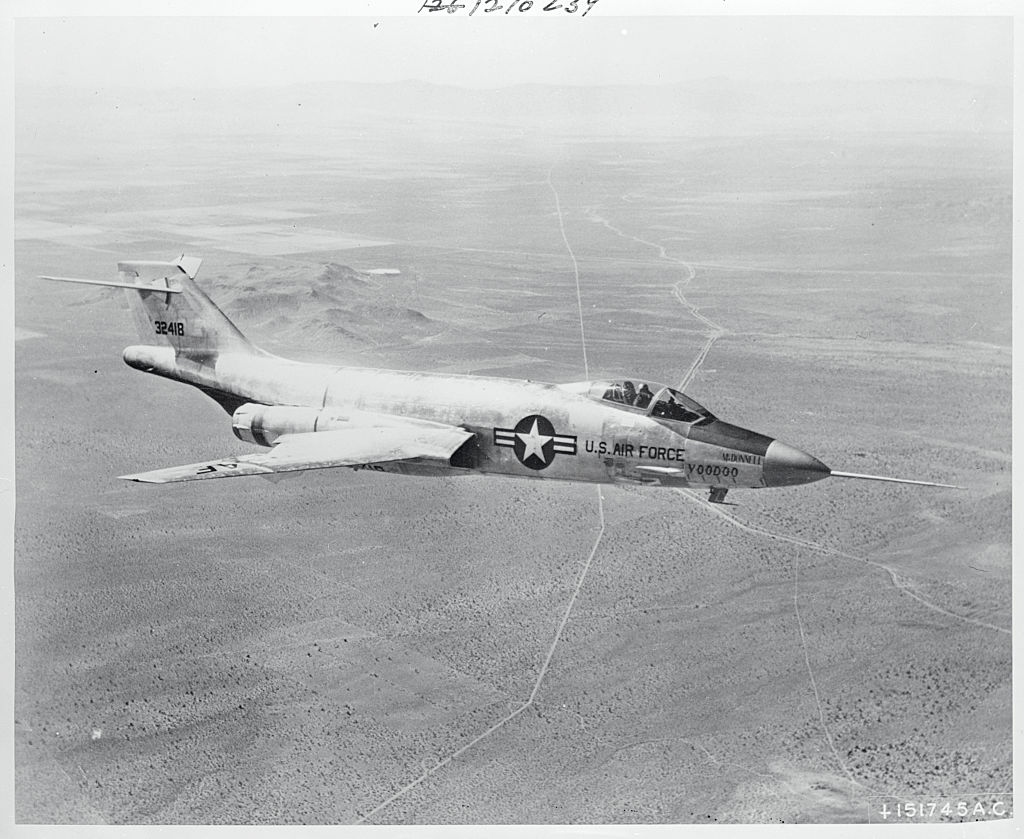 The McDonnell F-101 is captured in aerial view flying far above land.