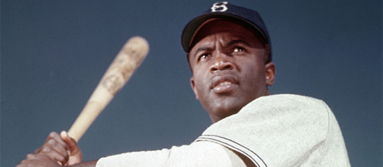 jackie robinson holding a bat in uniform