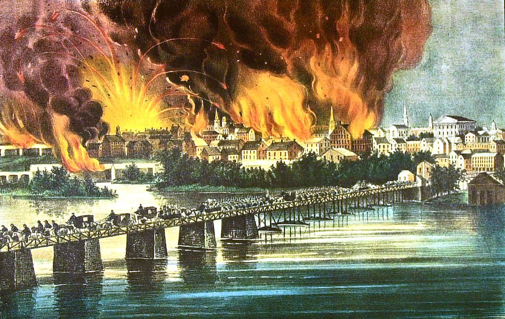 People escape from a burning town.