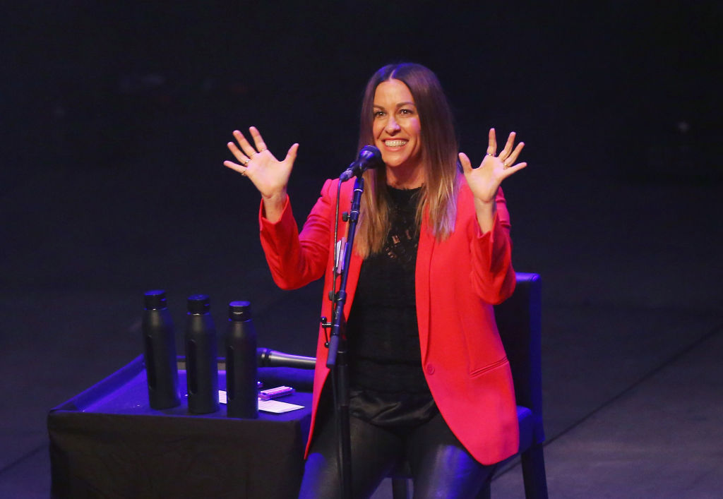 alanis morissette raising her hands on stage