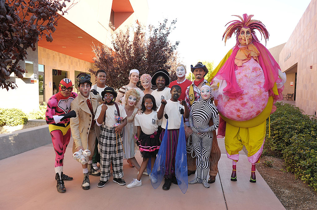 Cast members of Cirque du Monde pose for photos with students