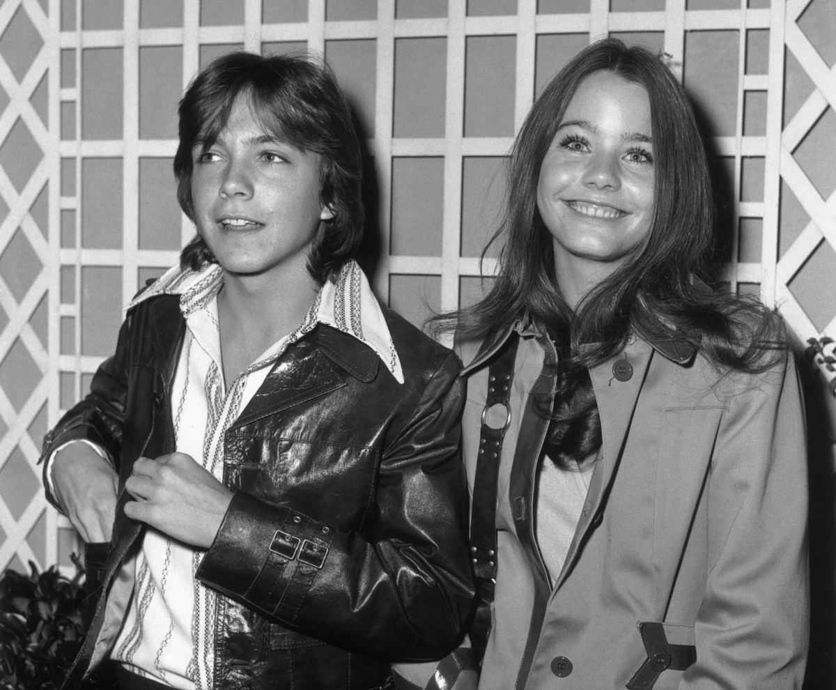 American actors David Cassidy and Susan Dey, costars of the television series 'The Partridge Family,' stand together and smile.