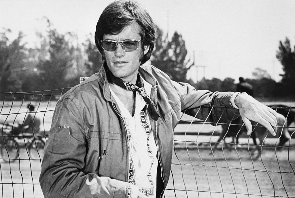 Fonda leaning against a fence
