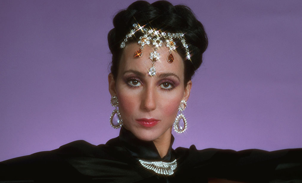 Cher posing with costume and jewelry