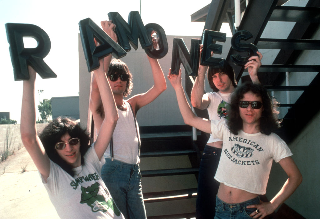 The Ramones holding up a sign of their band name