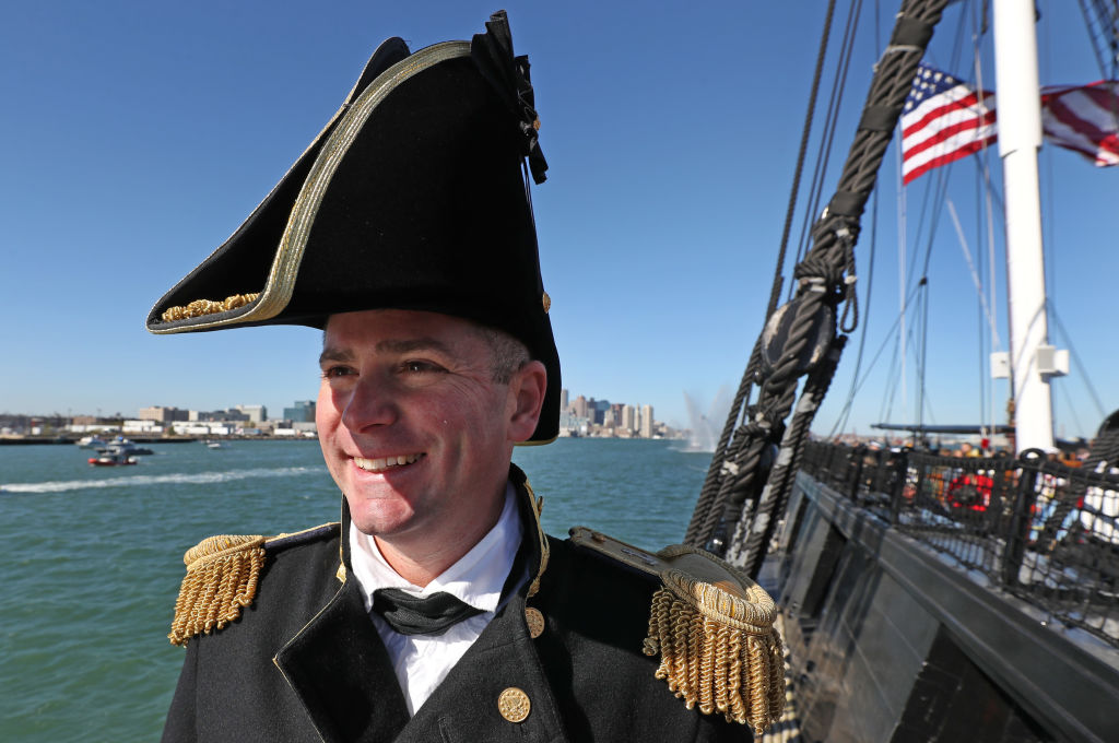A captain smiles near the USS Constitution.