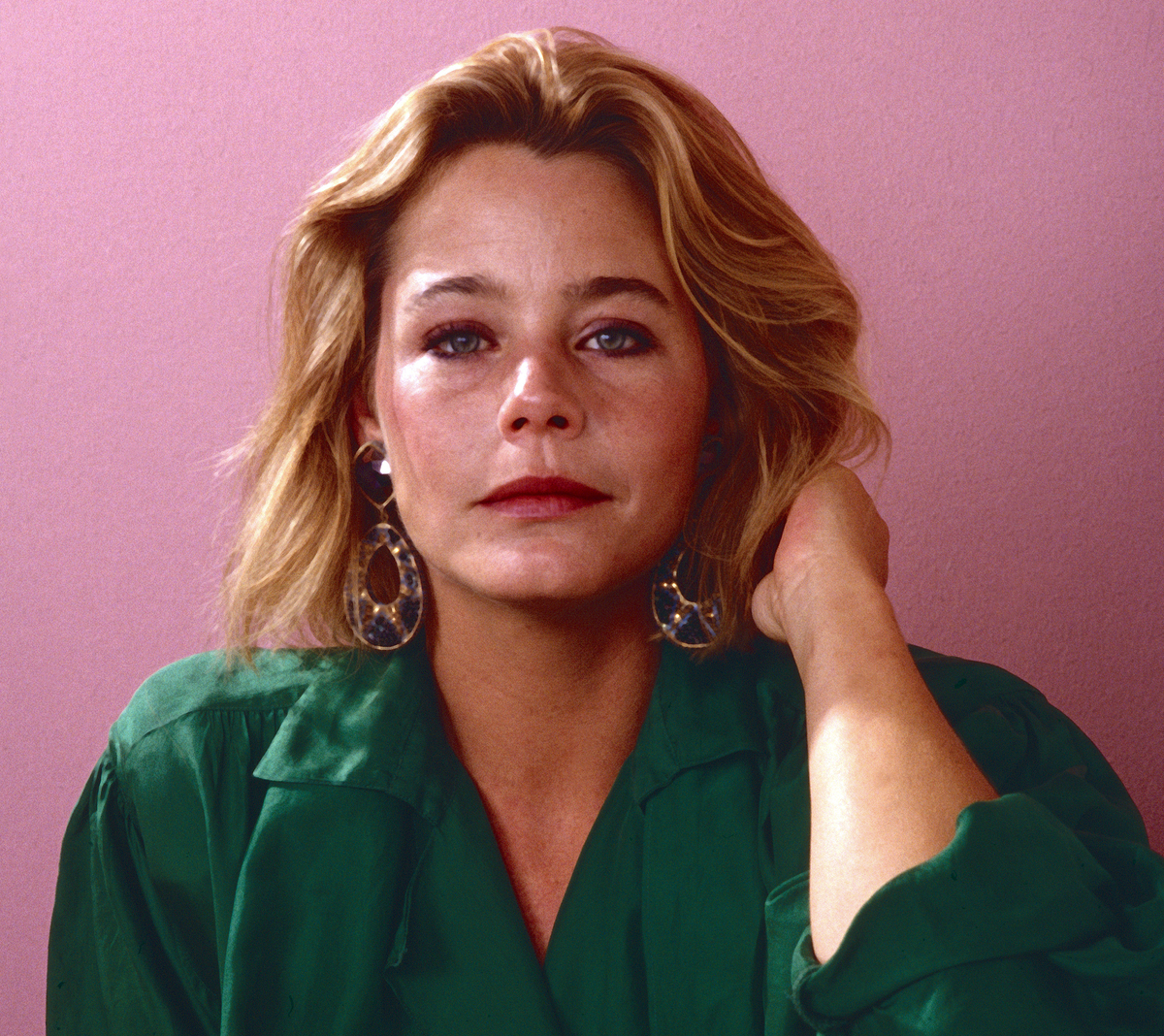 Actress Susan Dey poses in an emerald green shirt against a pink background, 1986.