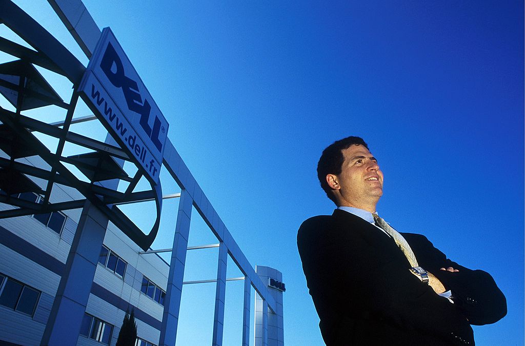 michael dell standing in front of a building with the dell logo