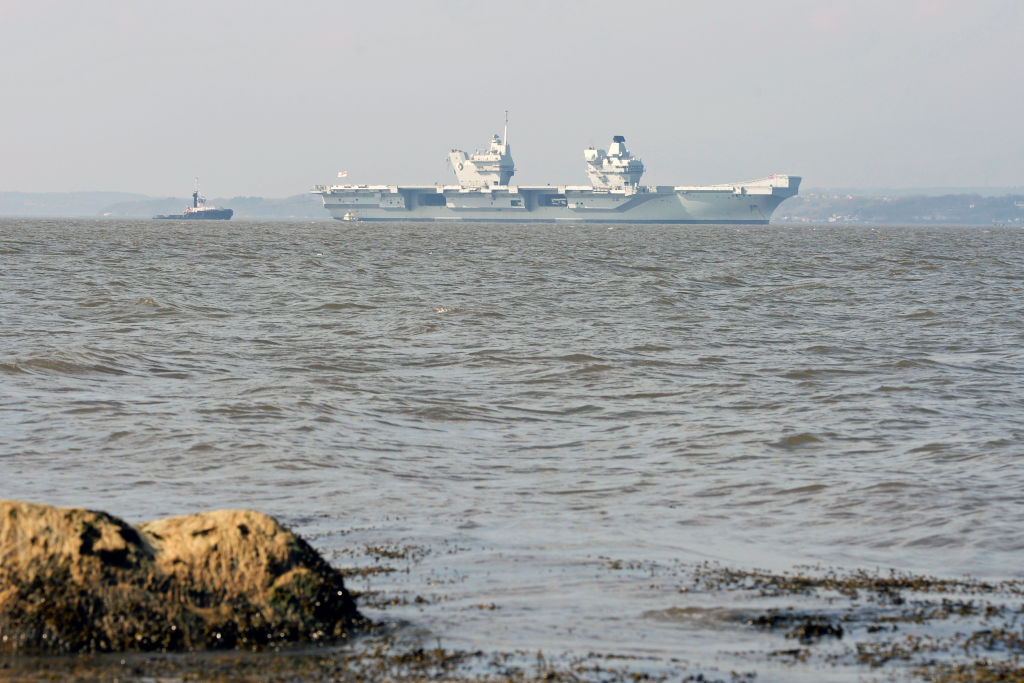 A photo from the shore shows the HMS Queen Elizabeth in the distance.
