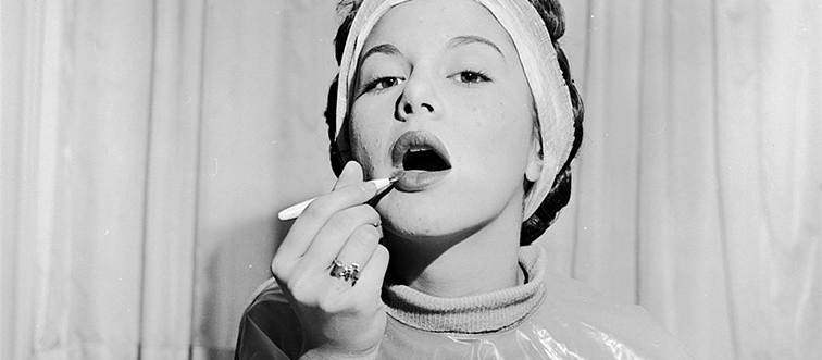a woman applying lipstick