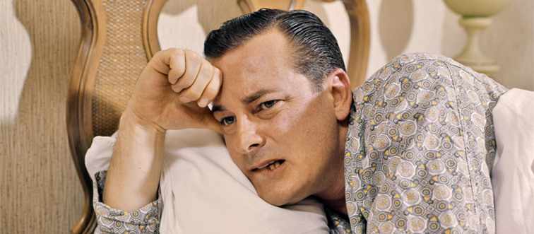 a man sitting up in bed