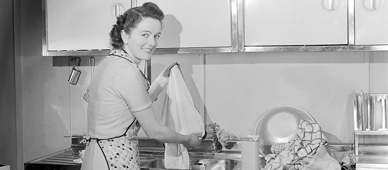 a woman washing things in her kitchen sink