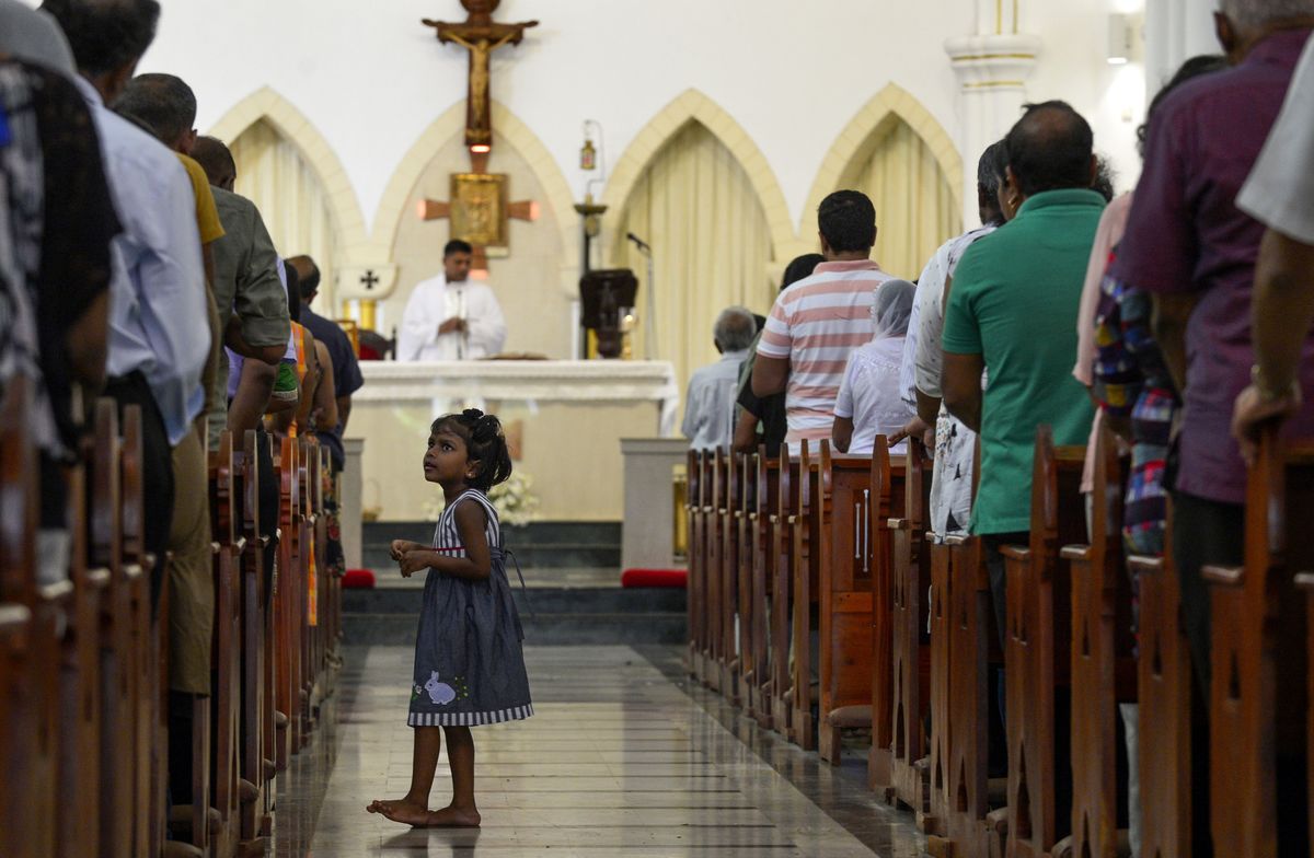 Sri Lankan Catholic devotees stand during a mass at the St. Theresa's church.