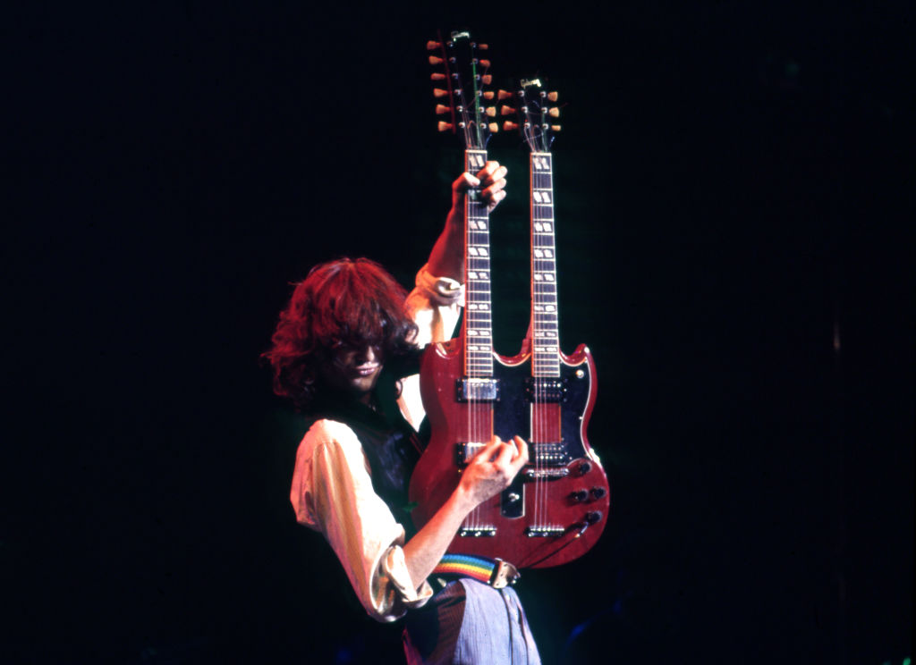 Jimmy Page plays a double-neck guitar onstage.