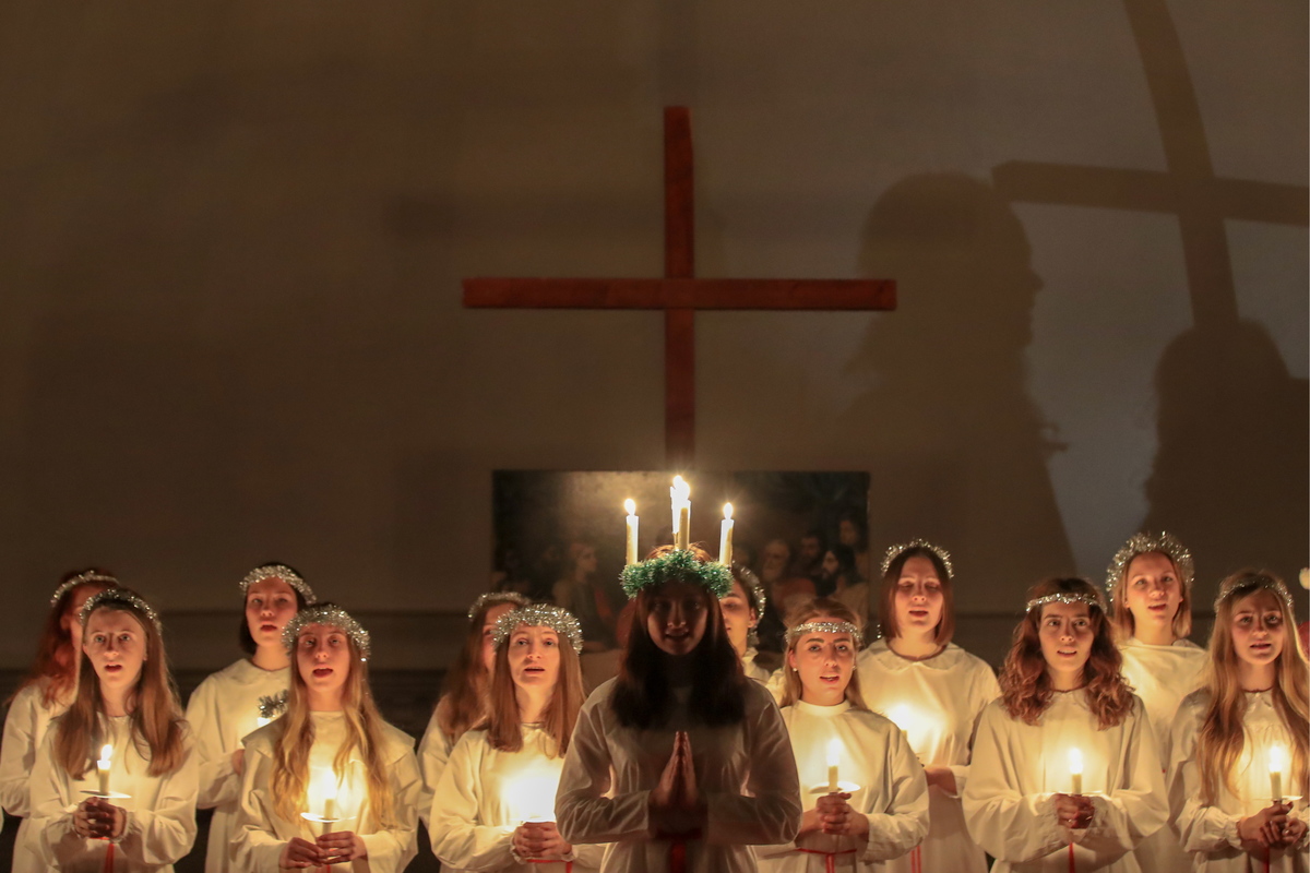 Girls hold lit candles during a celebration of Saint Lucy's Day.