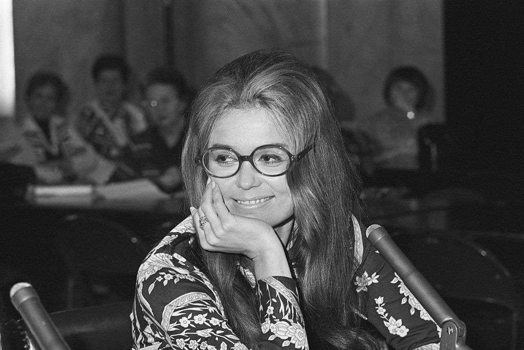 Gloria Steinem smiles at a press conference.