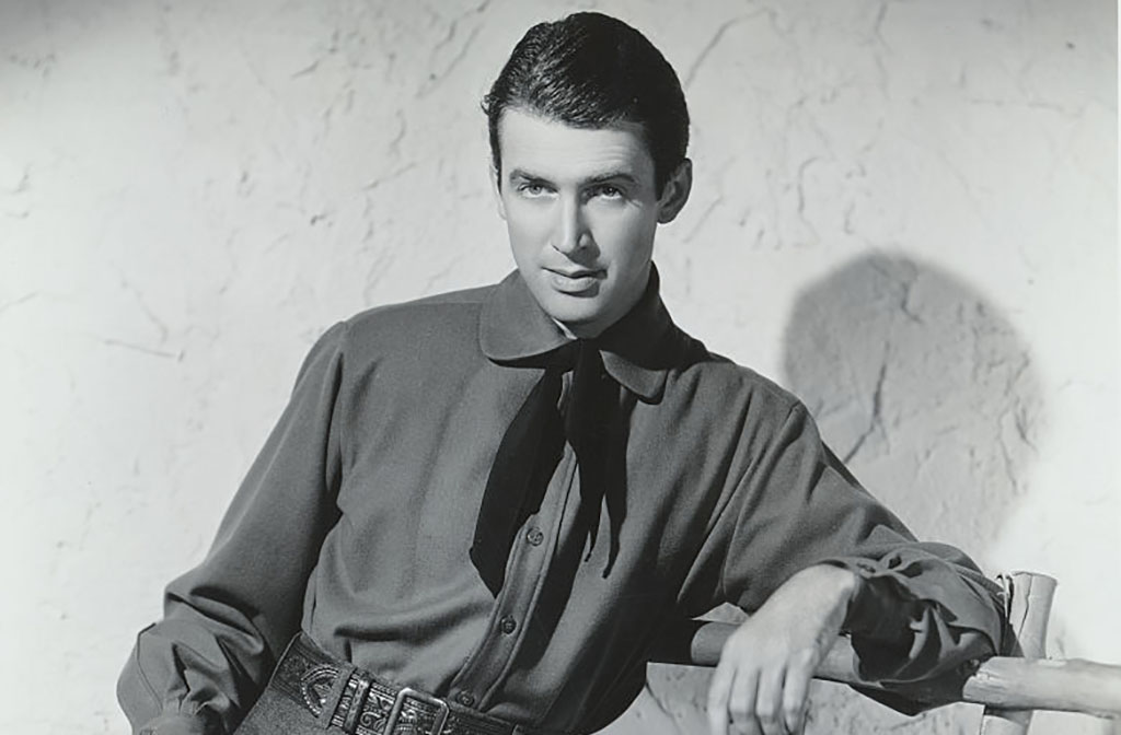 Jimmy Stewart leaning against a gate 