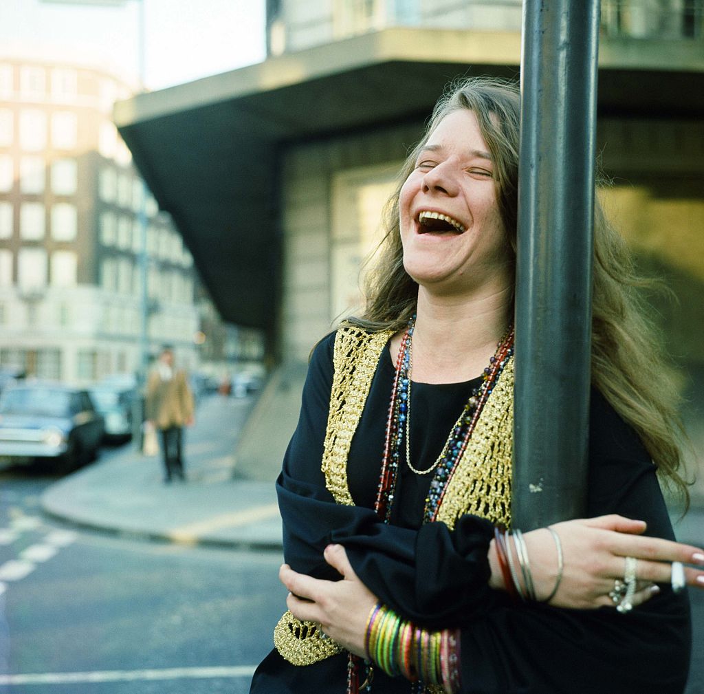Janis Joplin laughs on a street corner.