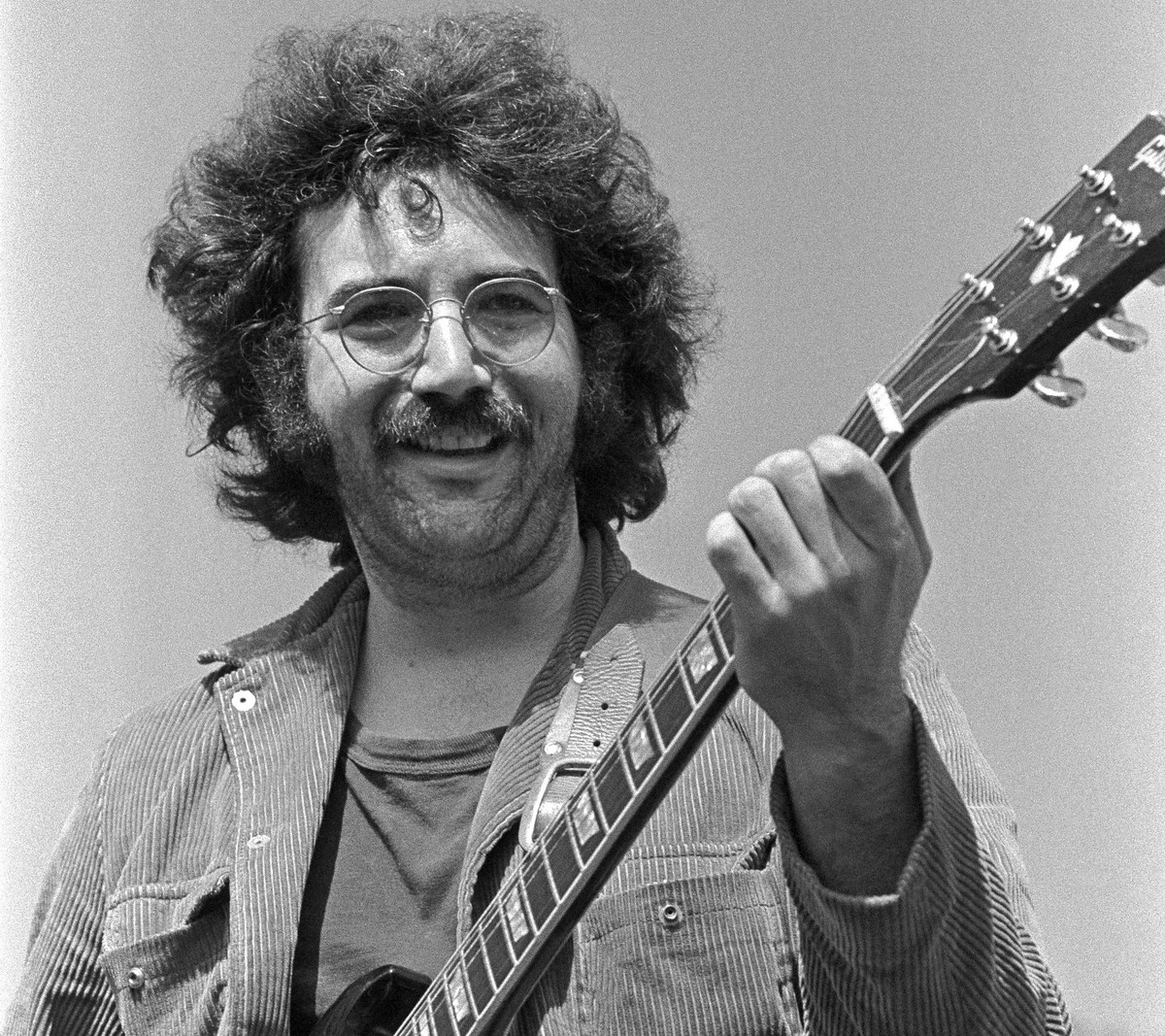 Jerry Garcia plays his guitar outside.