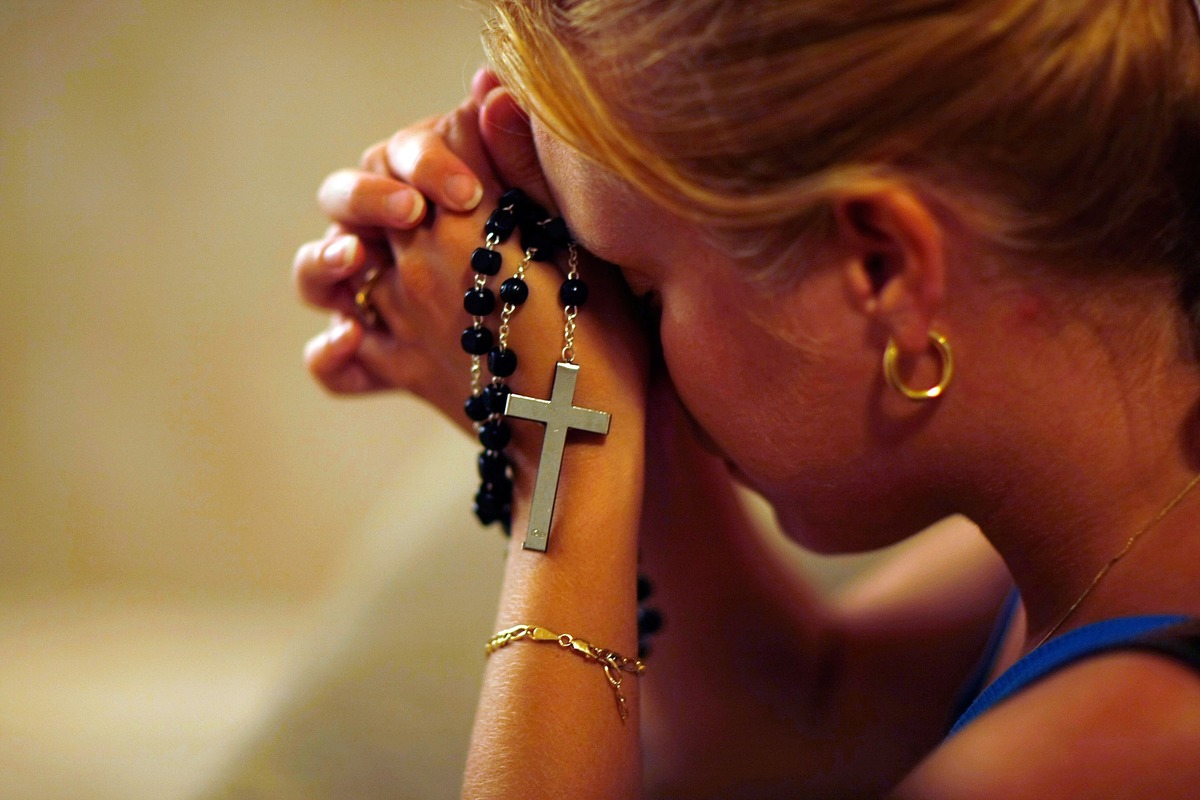 A woman prays with her rosary.