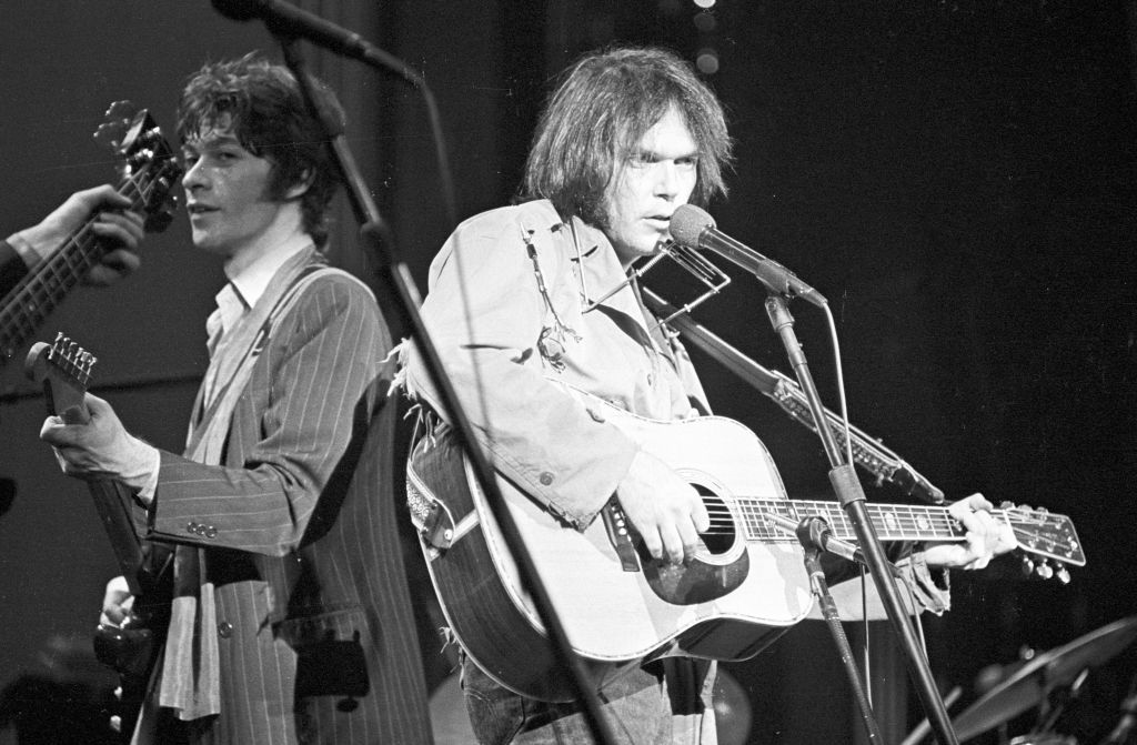 neil young and robbie robertson performing on stage
