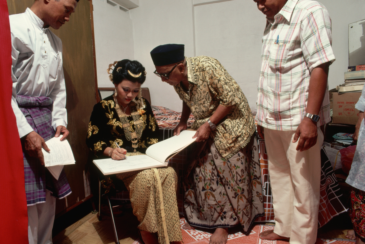 malaysian bride signing marriage document