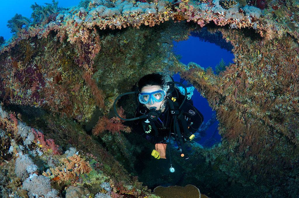 Diver swimming through shipwreck 