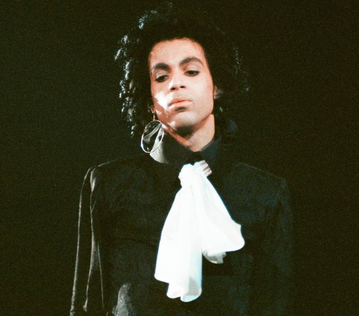 Prince looks down while performing on stage.