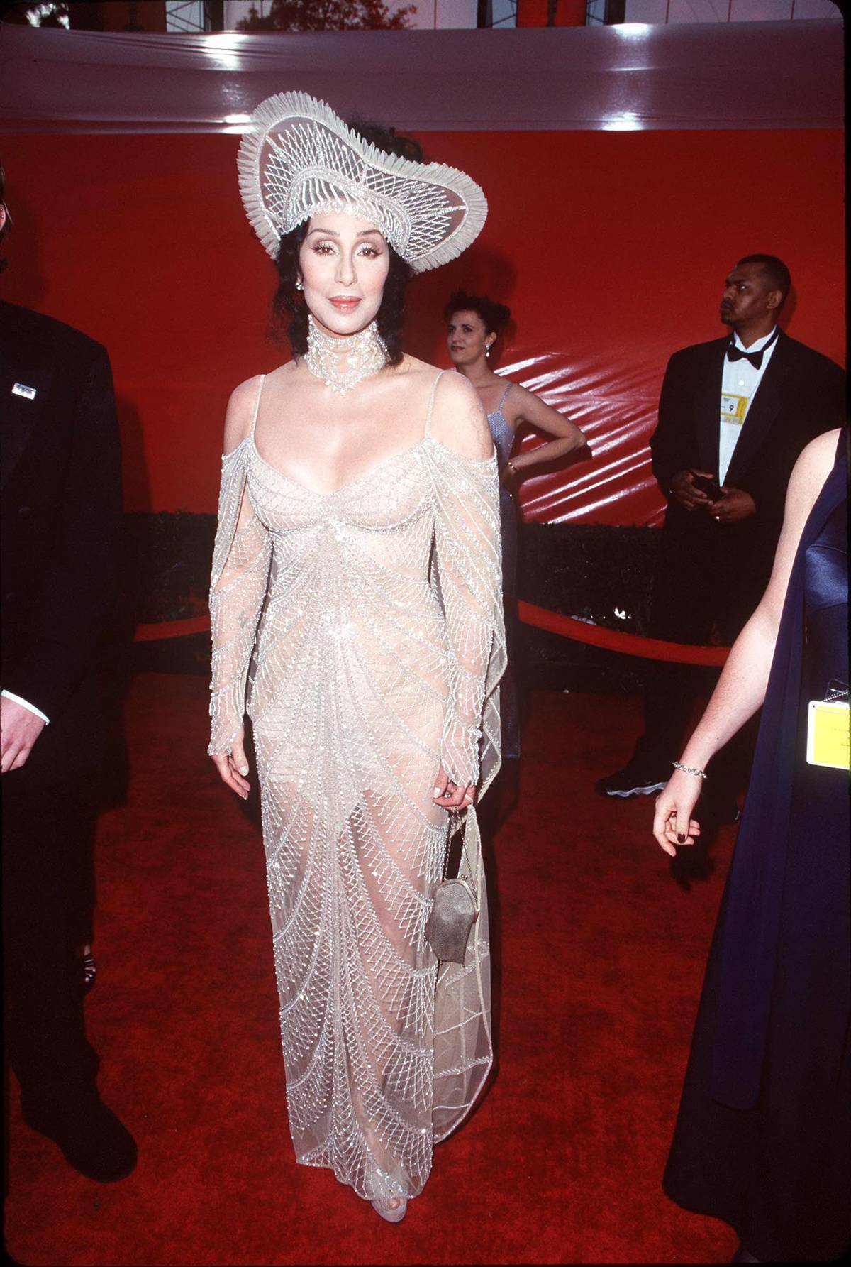 Cher wears a light gown and matching hat to an event.