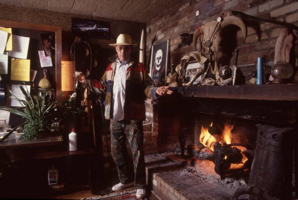Hunter Thompson aka Hunter S Thompson aka Gonzo Journalist at his ranch standing next to his fireplace