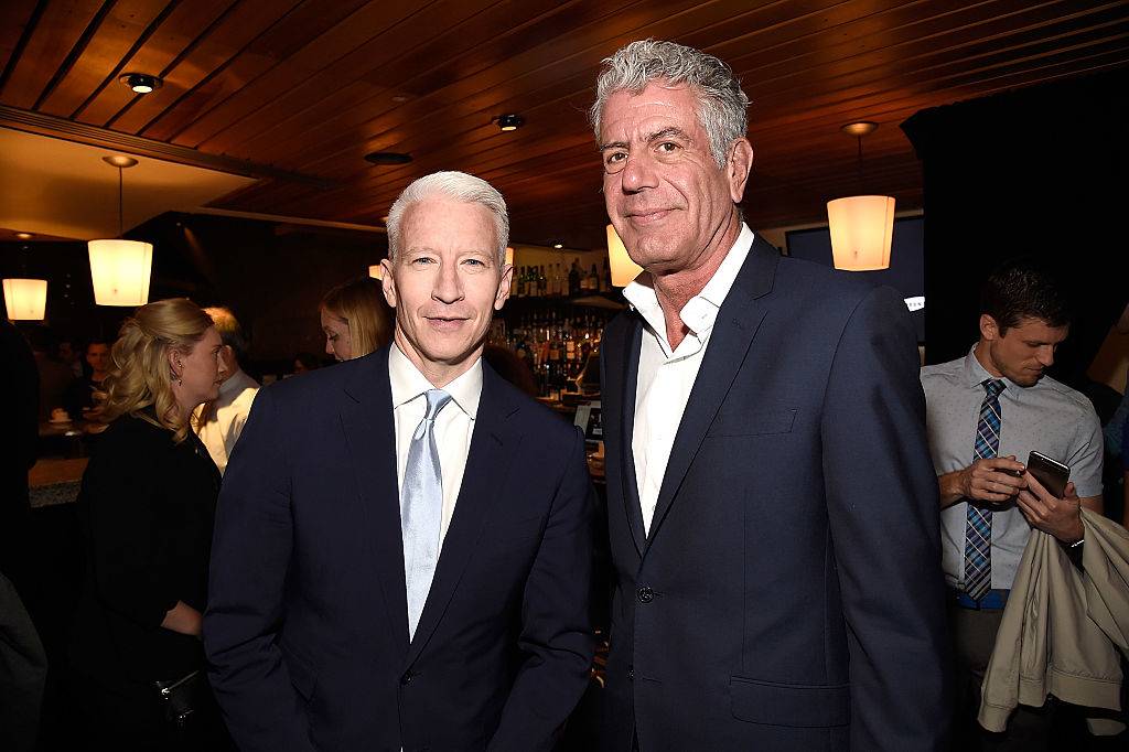 anthony bourdain and cooper posing for a photo