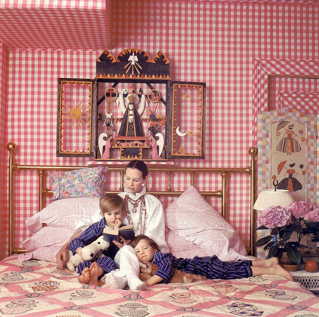 cooper with his brother and mother reading in a bed