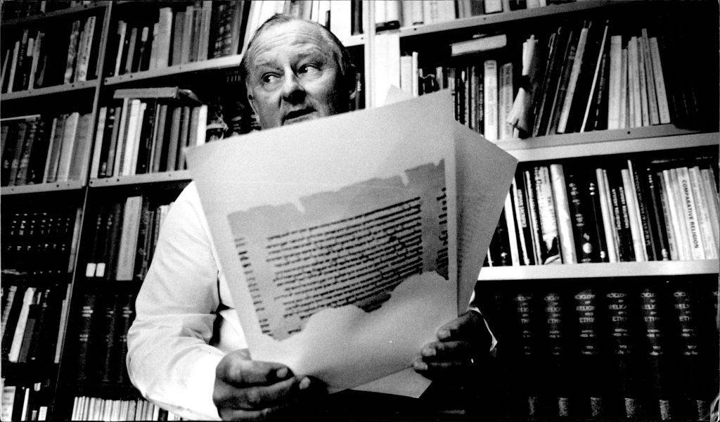 Man looking at copies of the Dead Sea Scrolls 