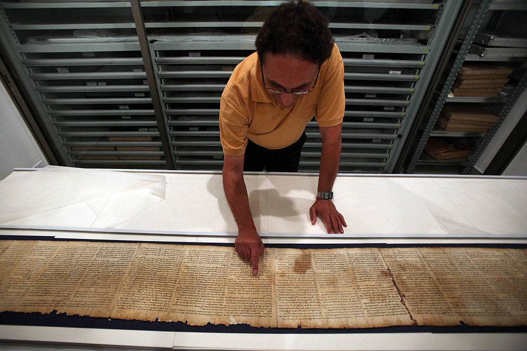 Man examining the Dead Sea Scroll 