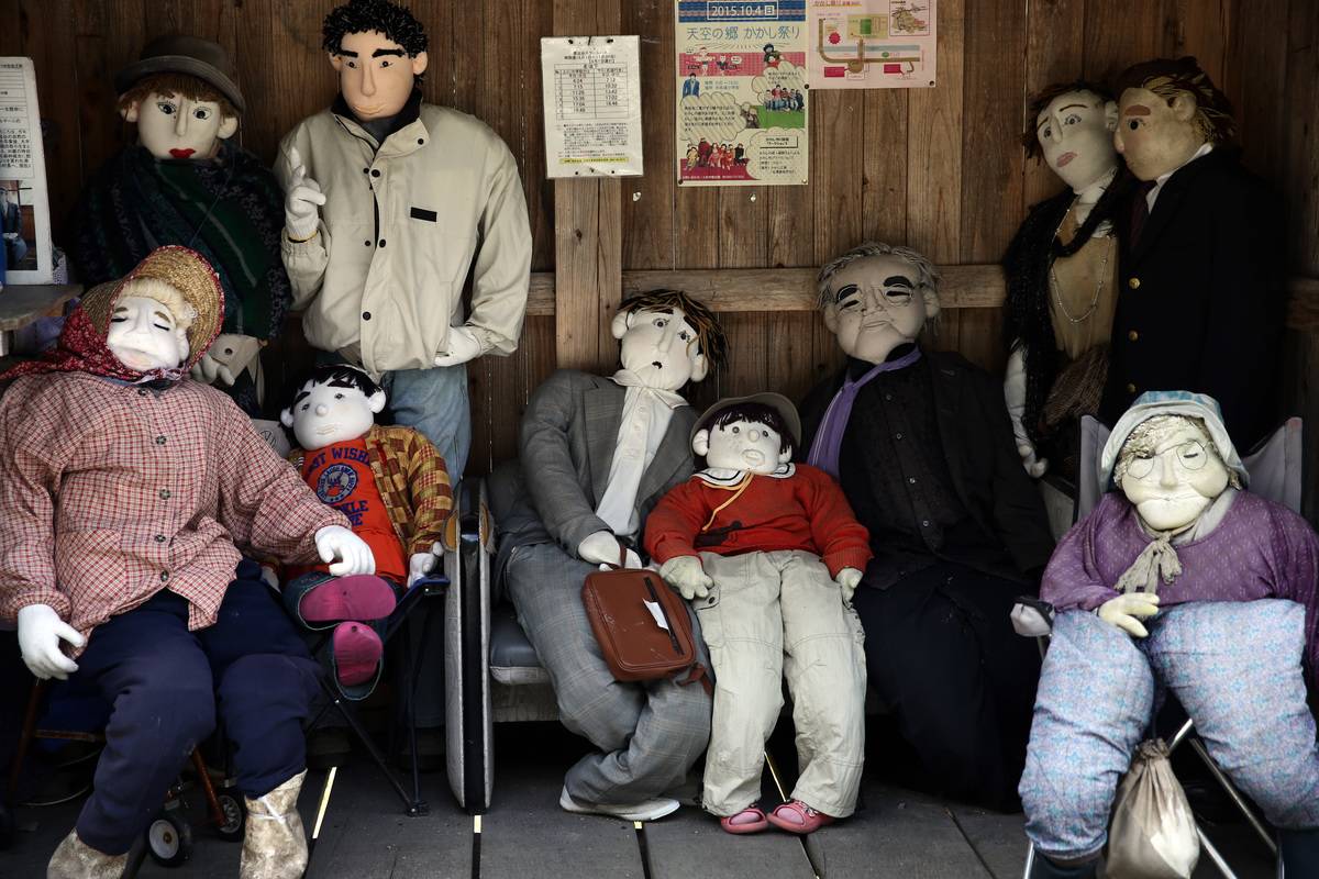 Hand-made dolls sit in a shelter