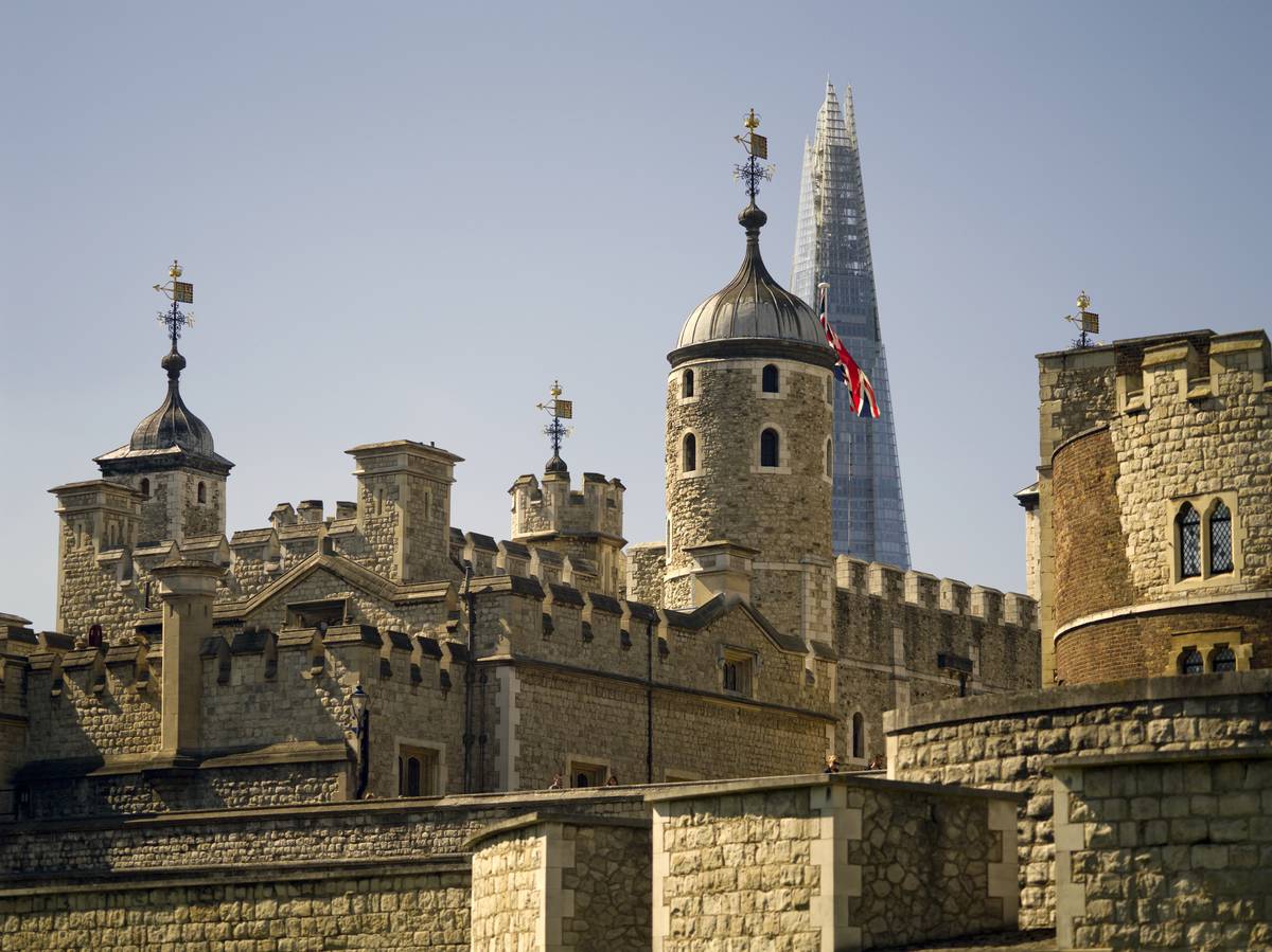 A view of the Tower of London with the top of The Shard behind it
