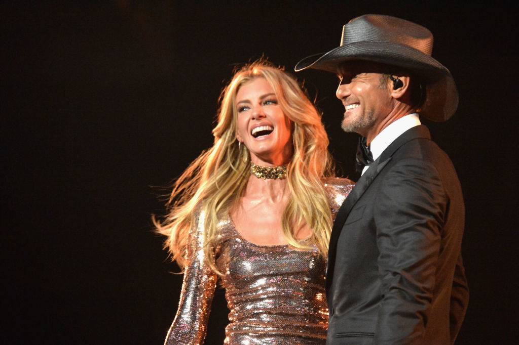 Faith and Tim smile onstage.