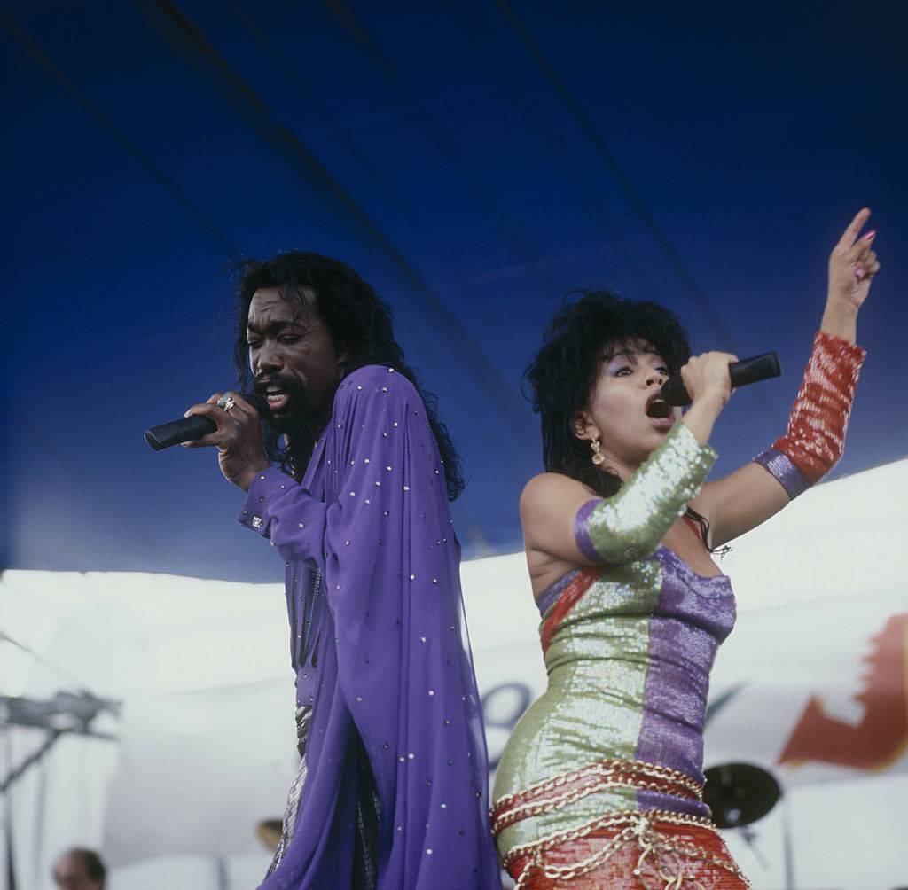 Nick and Valerie sing back to back onstage.
